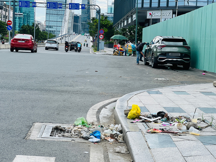 Nước mưa cuốn rác thải tụ quanh miệng cống thoát nước đường R12, lâu ngày không dọn - Ảnh: XUÂN ĐOÀN