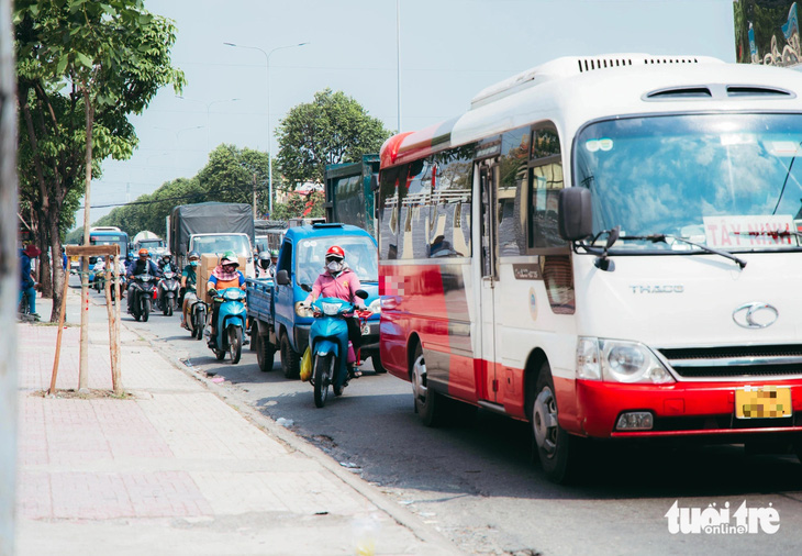 Nhiều người đi xe máy phải len lỏi giữa hàng dài xe ô tô trên chính làn xe máy - Ảnh: THANH HIỆP