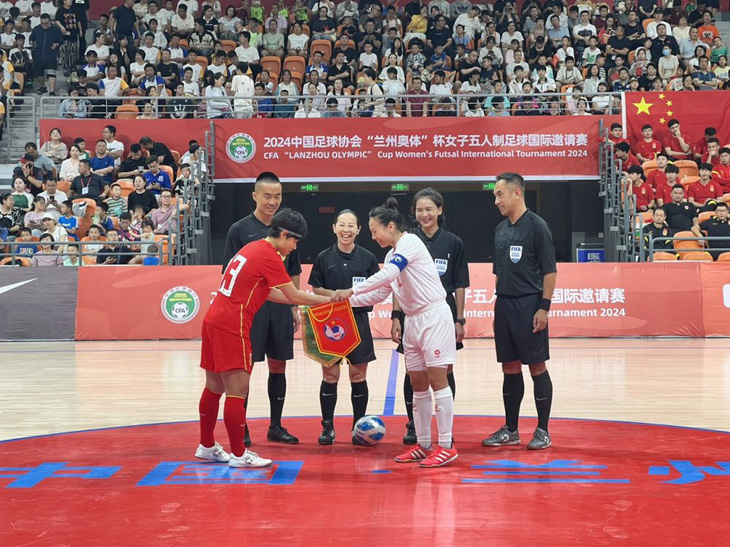 Đội tuyển futsal nữ Việt Nam (phải) tặng cờ lưu niệm trước trận đấu cho Trung Quốc - Ảnh: VFF