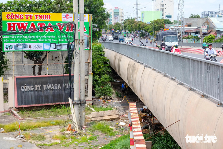 Hiện trạng dạ cầu phía quận Tân Phú vẫn còn vướng giải phóng mặt bằng nên chưa thể làm đường dân sinh - Ảnh: PHƯƠNG NHI