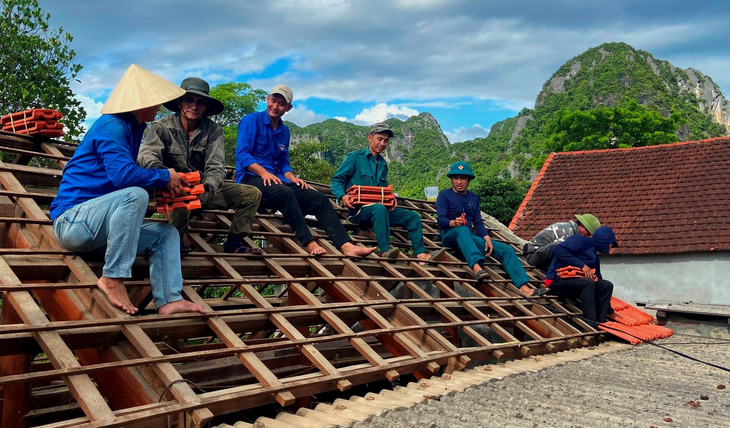 Để tiết kiệm chi phí, các bạn trẻ tại địa phương đã được huy động để tham gia lợp mái nhà - Ảnh: QUỐC NAM