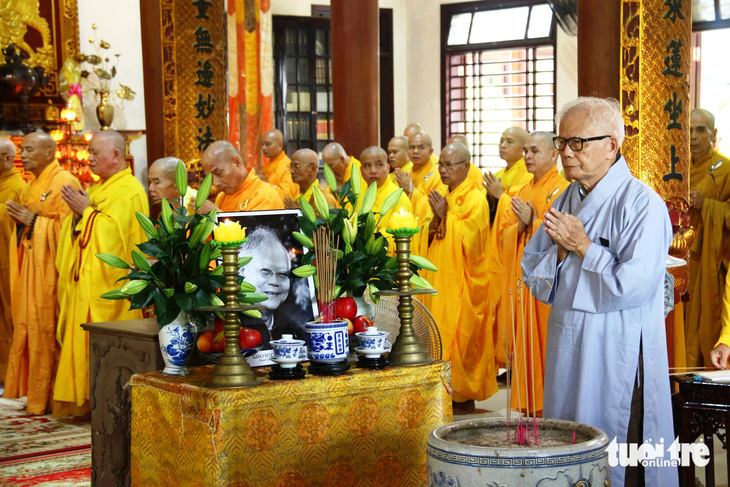 Ông Cao Huy Hóa (áo lam) bên di ảnh anh trai Cao Huy Thuần - Ảnh: NHẬT LINH