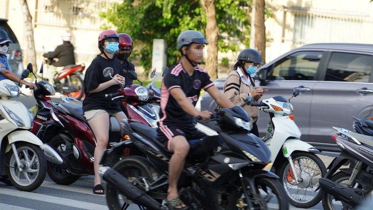 Cô gái đứng bấm điện thoại ở làn đợi rẽ trái trên đường Phạm Văn Đồng, TP Thủ Đức - Ảnh: ĐỊNH DƯƠNG