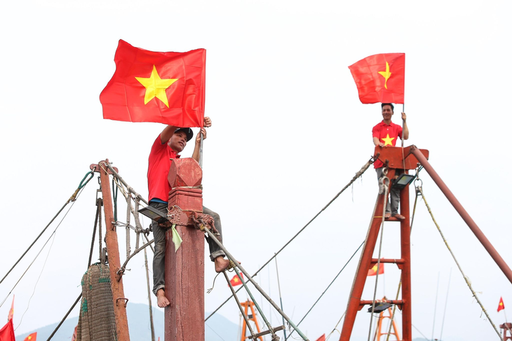 Ngư dân tỉnh Nghệ An treo cờ Tổ quốc từ Chương trình “Tự hào cờ Tổ quốc” - Ảnh: HOÀNG TRIỀU/BTC