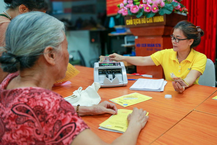 Nhân viên bưu điện chi trả lương hưu trực tiếp tại một điểm chi trả tại Hà Nội - Ảnh: HÀ QUÂN