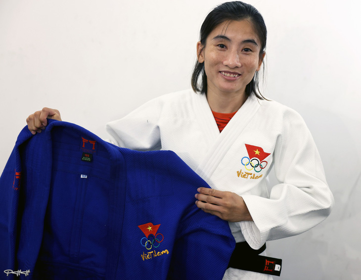 Nữ võ sĩ judo Hoàng Thị Tình cùng hai bộ trang phục thi đấu được thiết kế đặc biệt cho Olympic 2024 - Ảnh: PHẠM HỮU HẠNH