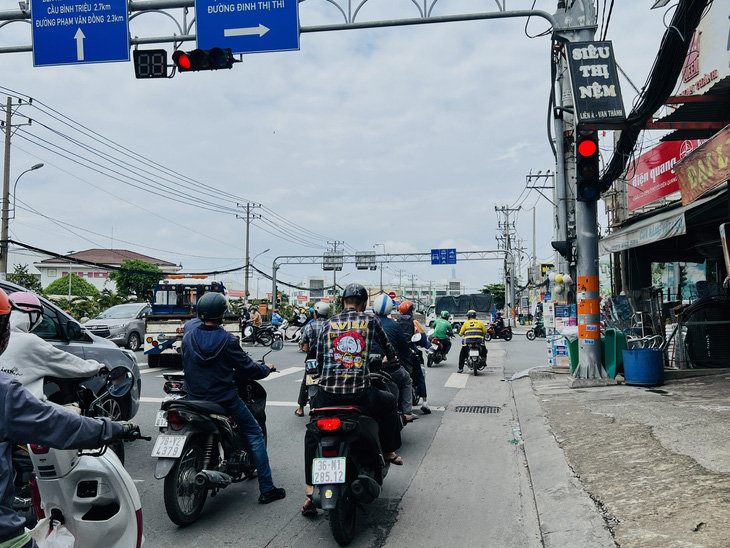 Một người luồng lách để rẽ phải khi đèn đỏ - Ảnh: XUÂN ĐOÀN