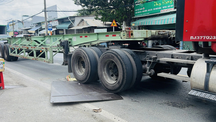 Mỗi lần bánh xe cán lên là tấm thép kêu rầm rầm, trượt dần ra khỏi hố ga - Ảnh: XUÂN ĐOÀN