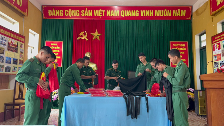 Cán bộ, chiến sĩ Đồn biên phòng Ga Ri chuẩn bị băng tang và cờ Tổ quốc để phát cho bà con - Ảnh: PHÚC TRƯỜNG