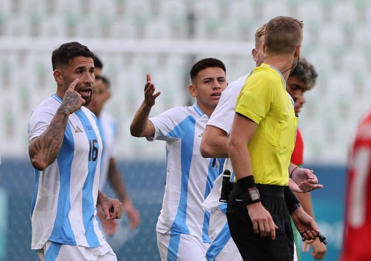 Các cầu thủ Argentina phân trần với trọng tài khi trở lại thi đấu và bị hủy bàn thắng - Ảnh: REUTERS