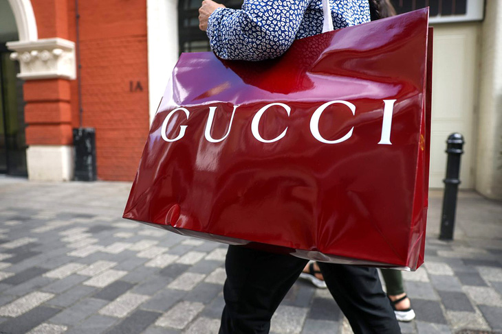 Một khách hàng cầm chiếc túi mua sắm hiệu Gucci ở London, Vương quốc Anh - Ảnh: Bloomberg