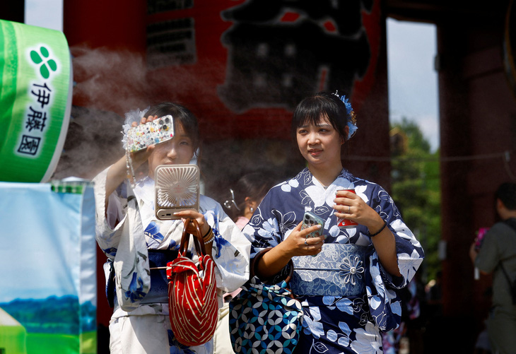 Phụ nữ Nhật Bản dưới cái nóng gay gắt của Tokyo, ngày 22-7 - Ảnh: REUTERS