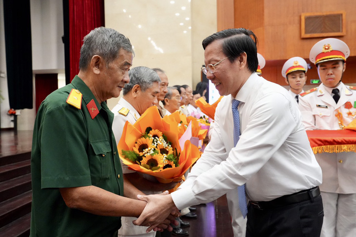 Chủ tịch UBND TP.HCM Phan Văn Mãi trao quà cho người có công tiêu biểu - Ảnh: HỮU HẠNH