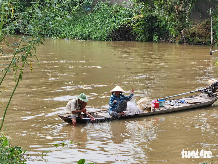 Đôi vợ chồng ở xã Vĩnh Châu, TP Châu Đốc đang thăm lưới khi con nước đổi màu - Ảnh: BỬU ĐẤU