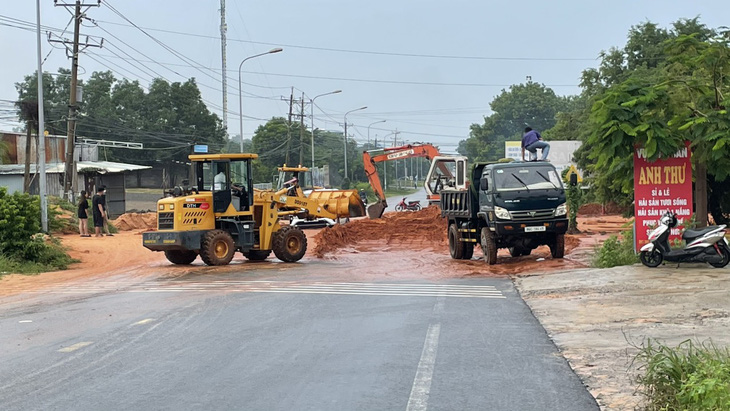 TP Phan Thiết huy động máy móc dọn dẹp cát đỏ vừa tràn xuống lúc sáng 27-7, gây chia cắt đường Nguyễn Thông - Ảnh: MAI THỨC