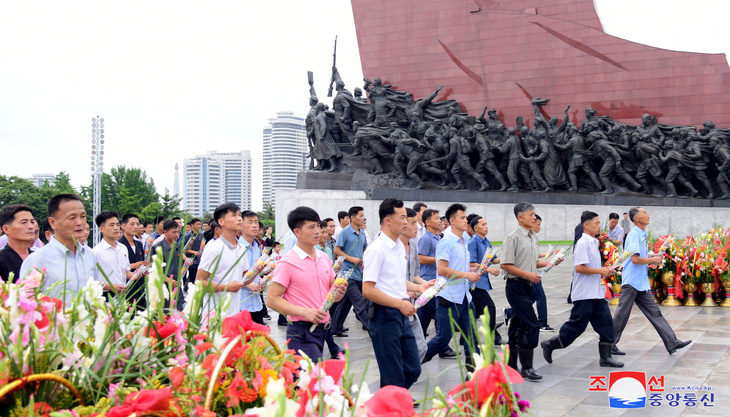 Người dân Triều Tiên đến đặt hoa tại tượng đài hai cố lãnh đạo Kim Nhật Thành và   Kim Chính Nhật  trong ngày kỷ niệm 71 năm đình chiến - Ảnh: REUTERS