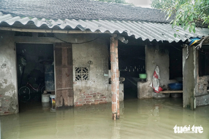 Nước ngập sâu, người dân bỏ lại nhà cửa, tài sản đi sơ tán - Ảnh: PHẠM TUẤN