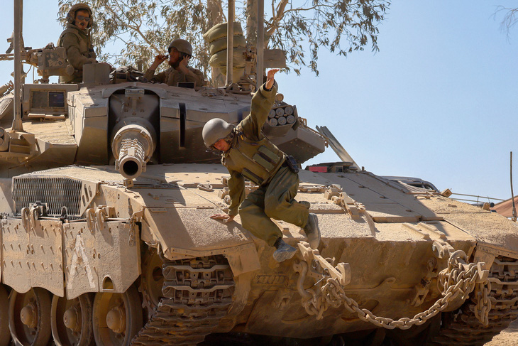 Binh sĩ Israel vận hành một chiếc xe tăng tiến về khu vực biên giới giữa nước này và Dải Gaza ngày 2-7 - Ảnh: AFP