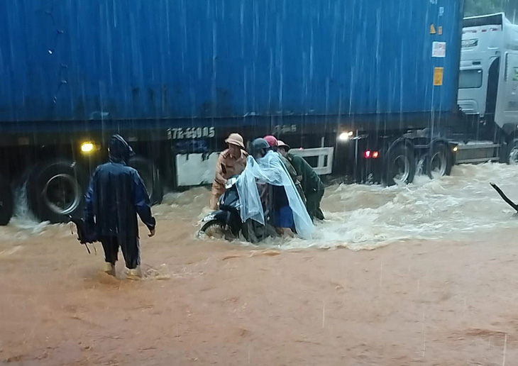 Lực lượng cảnh sát giao thông hỗ trợ người dân đi qua khu vực ngập sâu trên quốc lộ 2 đoạn qua huyện Vị Xuyên - Ảnh: N. HOÀN