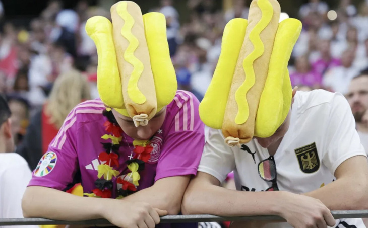 Hai cổ động viên của đội tuyển Đức thiết kế chiếc mũ để đi cổ vũ, lấy cảm hứng từ món bánh hotdog kẹp xúc xích nổi tiếng - Ảnh: AFP