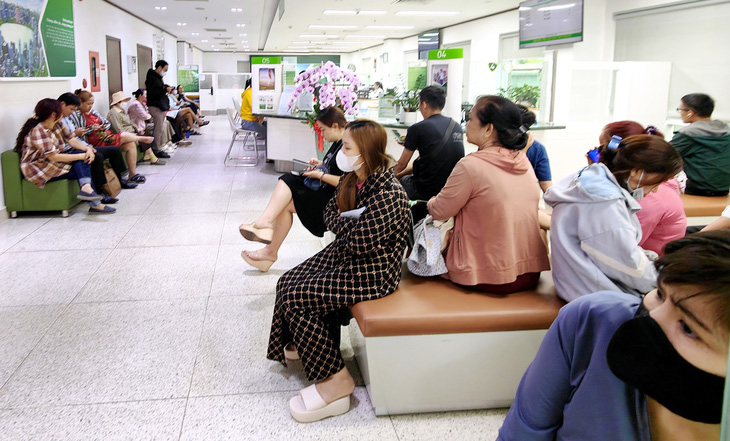 Khách hàng chờ đến lượt giao dịch tại ngân hàng trên đường Phan Đăng Lưu, quận Phú Nhuận trong sáng 2-7 - Ảnh: ĐỨC THIỆN