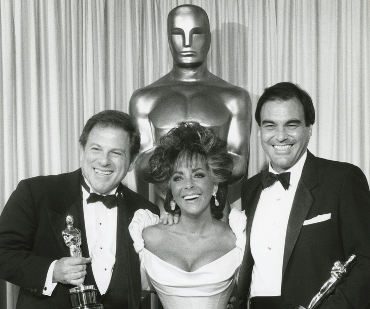 Oliver Stone (phải) nhận giải Oscar năm 1987 cho Platoon từ tay huyền thoại điện ảnh Elizabeth Taylor - Ảnh: X của Oliver Stone