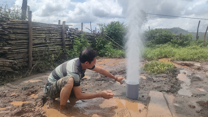 Cột nước kèm theo dòng khí phun trào rất mạnh qua miệng giếng khoan của gia đình ông Đàm Xuân Hòa - Ảnh: K.L. 