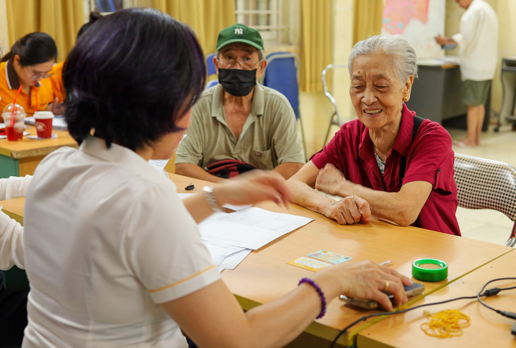 Người cao tuổi nhận lương hưu tại một điểm chi trả ở Hà Nội - Ảnh: THÚY TRANG