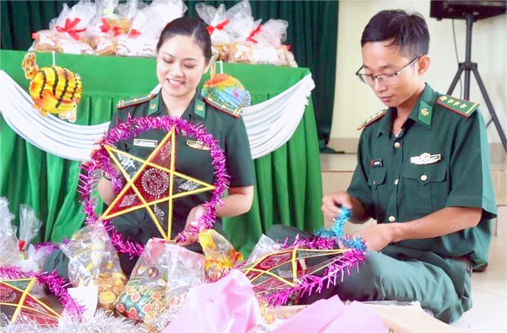 Thượng úy Phạm Thái Sơn (phải) cùng đồng đội chuẩn bị lồng đèn và quà cho trẻ em vùng cao đón trung thu - Ảnh: LINH CHI
