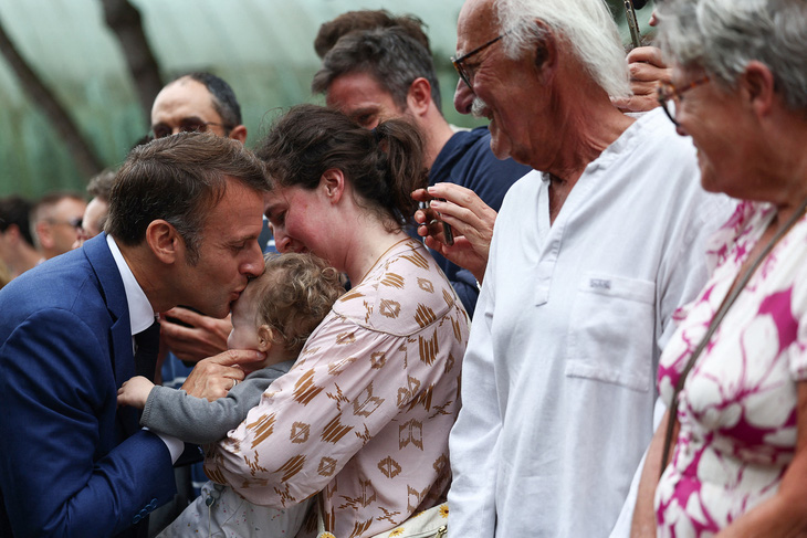 Tổng thống Pháp hôn lên trán một em bé trong buổi giao lưu với những người ủng hộ ông sau cuộc bỏ phiếu vòng đầu tiên ngày 30-6 - Ảnh: AFP