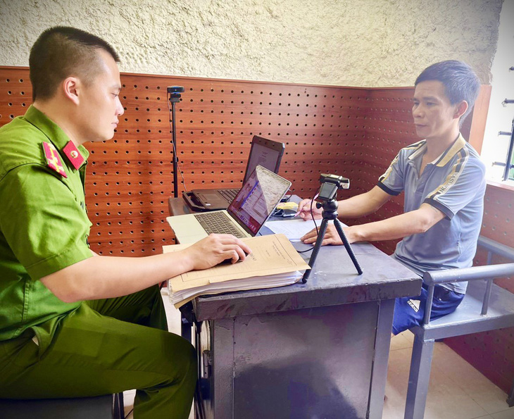 Nguyễn Khắc Giang (bên phải) tại cơ quan công an - Ảnh: CACC
