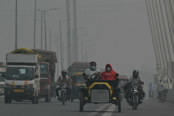Người dân di chuyển trên cầu Signature trong điều kiện sương mù dày đặc ở thủ đô New Delhi vào ngày 9-11-2023. Thủ đô của Ấn Độ thường xuyên được xếp hạng là một trong những nơi ô nhiễm nhất thế giới, do "hỗn hợp" khí thải từ nhà máy và xe cộ, cùng khói từ các đám cháy nông nghiệp vào đầu mỗi mùa đông - Ảnh: AFP