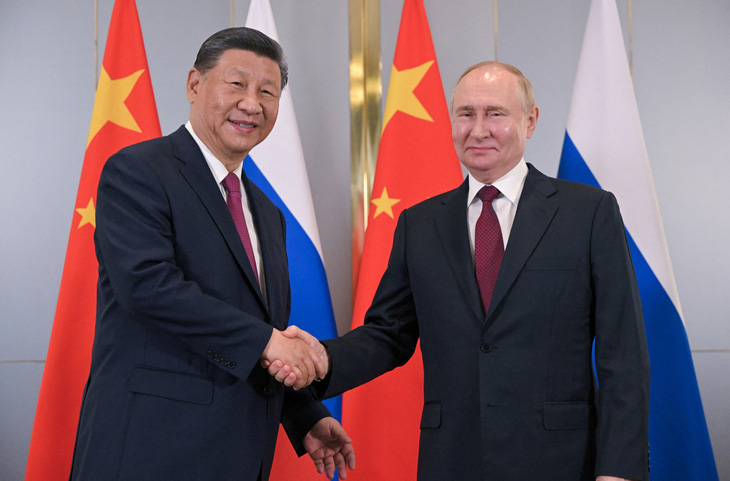 Tổng thống Nga Vladimir Putin (phải) và Chủ tịch Trung Quốc Tập Cận Bình bắt tay nhau trong cuộc gặp bên lề hội nghị thượng đỉnh Tổ chức Hợp tác Thượng Hải (SCO) tại Astana, Kazakhstan ngày 3-7 - Ảnh: REUTERS
