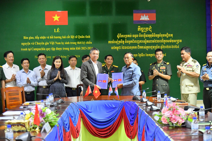 Ông Nguyễn Lưu Trung (bên trái) - phó chủ tịch UBND tỉnh Kiên Giang - ký tiếp nhận 10 bộ hài cốt liệt sĩ hy sinh trên đất bạn Campuchia - Ảnh: LÊ VŨ