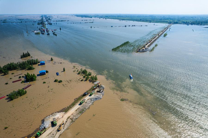 Ảnh chụp bằng máy bay không người lái vào ngày 6-7 cho thấy lực lượng cứu hộ tại vị trí con đê bị vỡ ở hồ Động Đình tại tỉnh Hồ Nam - Ảnh: TÂN HOA XÃ