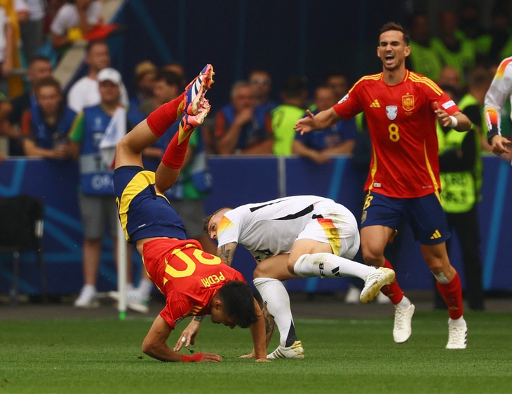 Toni Kroos có pha vào bóng vô cùng nguy hiểm với Pedri - Ảnh: REUTERS