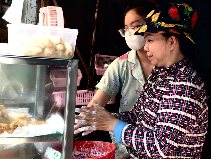 Cô Thảo cùng con gái bán chuối chiên ở chợ Ga. Trong cái nắng oi bức của thành phố, các cô, chú trong chợ Ga vẫn buôn bán trang trải cho cuộc sống - Ảnh: TRƯƠNG HUỲNH ANH THƯ