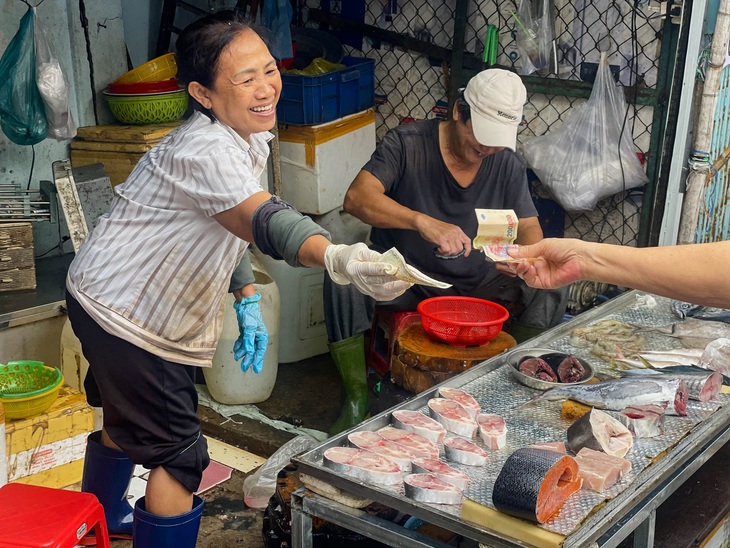 Nụ cười vui vẻ khi bán hàng của cô Hường tại chợ Ga - Ảnh: NGUYỄN QUỐC DUY
