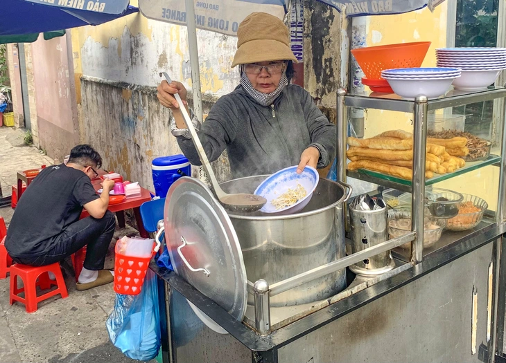 Cô Trần Thị Thanh Hà bán cháo lòng ăn với bánh quẩy tại đường rầy, kế bên chợ Ga - Ảnh: HUỲNH THỊ PHƯƠNG LINH