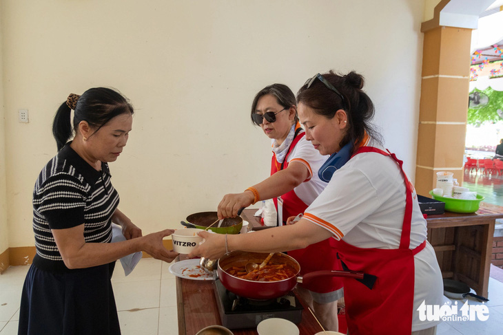 Người dân địa phương nhận món ăn truyền thống của Hàn Quốc tại Trại chữa lành - Ảnh: HOÀNG TÁO