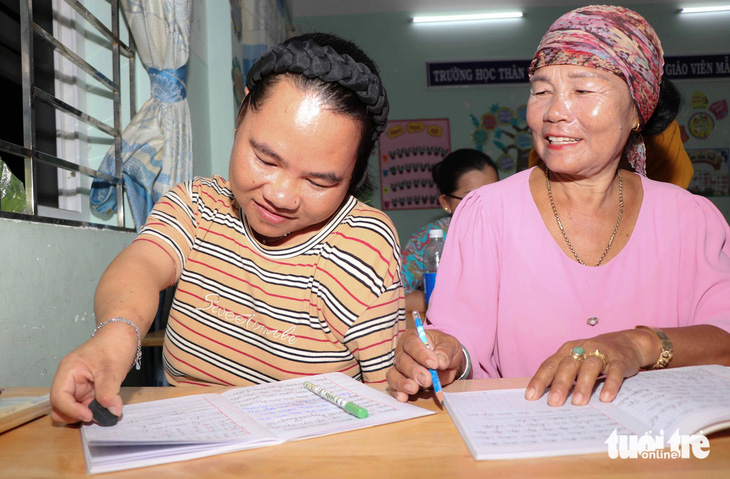 Dù mới học được gần 3 tháng, nhưng hai mẹ con bà Thành Thị Thiên và Lý Thị Hương đã đọc thông, viết thạo - Ảnh: DUY NGỌC