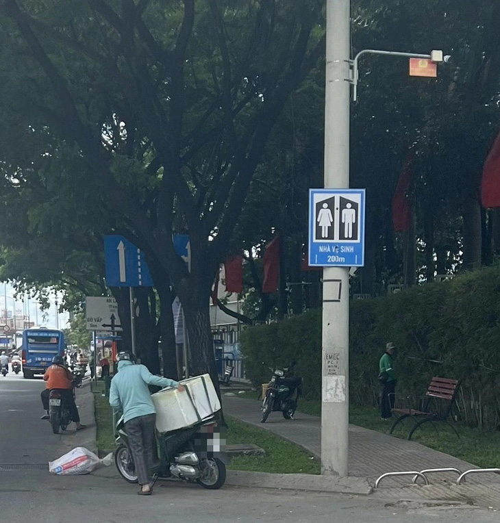 Một người đàn ông tiểu bậy trên vỉa hè đường Lê Thị Riêng, quận 12, TP.HCM trong khi nhà vệ sinh miễn phí chỉ cách đó khoảng 200m - Ảnh: ĐỊNH DƯƠNG