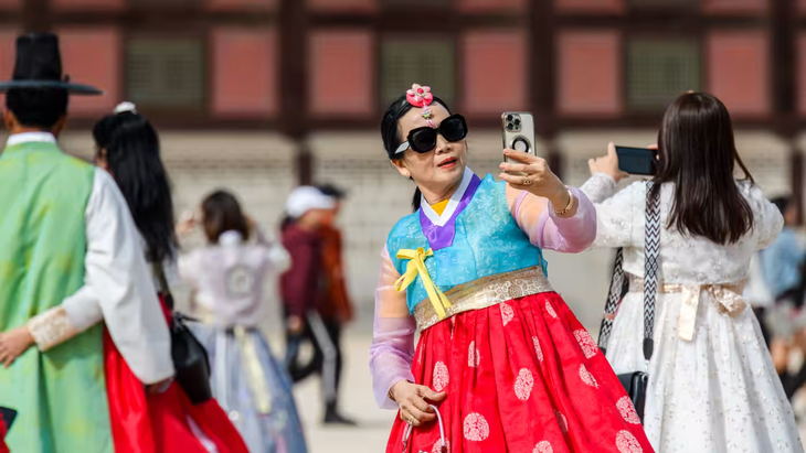 Một du khách nước ngoài chụp ảnh tại cung điện Gyeongbokgung, thủ đô Seoul trong bộ trang phục hanbok truyền thống của Hàn Quốc - Ảnh: GETTY IMAGES