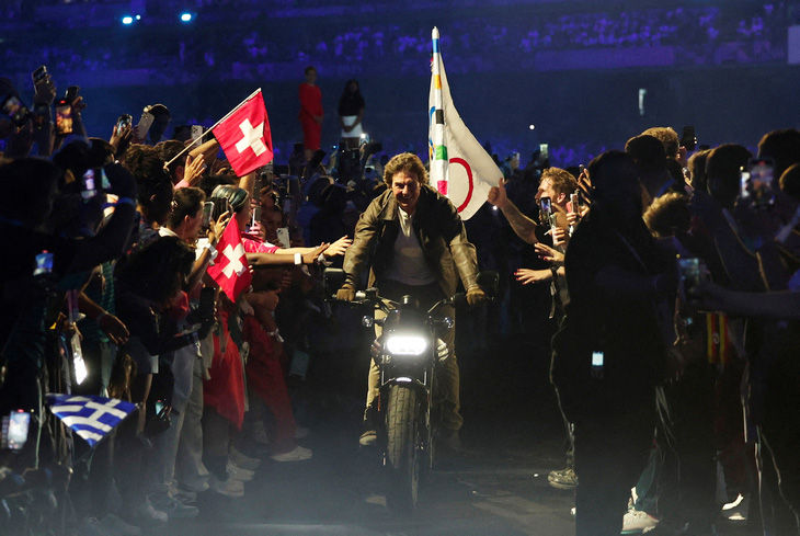 Nam tài tử Tom Cruise lái mô tô rời sân vận động Stade de France ở lễ bế mạc Olympic 2024 - Ảnh: REUTERS