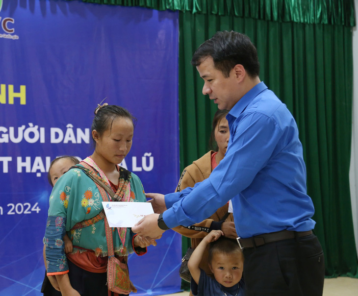 Anh Ngô Văn Cương - bí thư Trung ương Đoàn - trao quà cho bà con vùng lũ Sơn La - Ảnh: LÂM HẢI