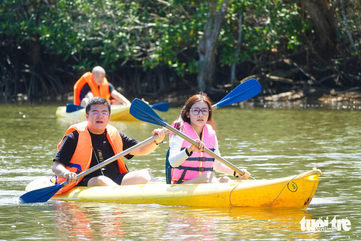 Khách quốc tế chèo kayak trên sông Cửa Cạn - Ảnh: CHÍ CÔNG