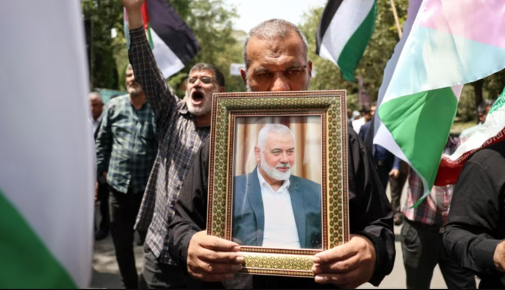 Người dân cầm di ảnh của thủ lĩnh Hamas Ismail Haniyeh và vẫy cờ Palestine ở thủ đô Tehran ngày 31-7 - Ảnh: SHUTTERSTOCK