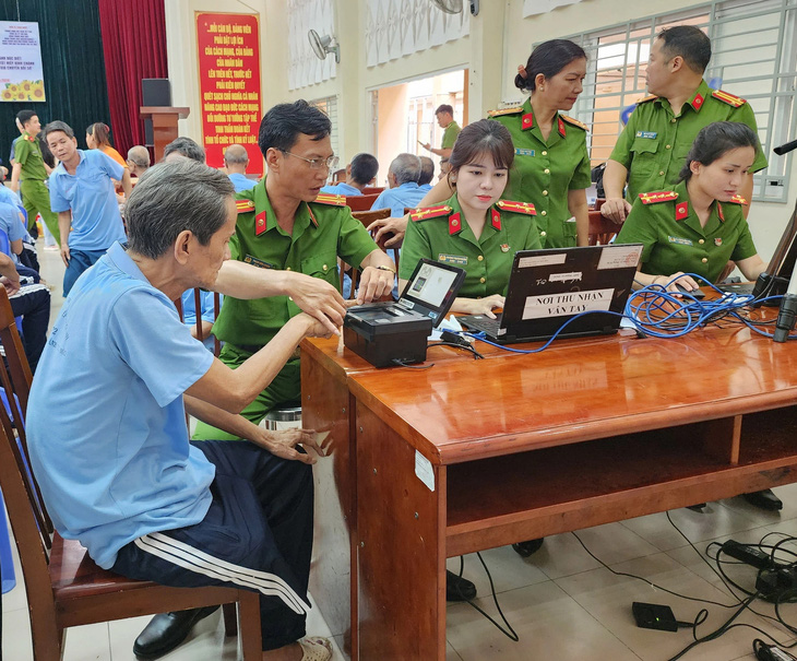 Các cán bộ, chiến sĩ Công an TP.HCM cấp căn cước cho những cô, chú khuyết tật - Ảnh: MINH HÒA