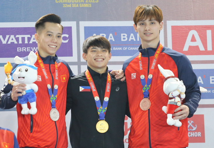 Carlos Yulo stands next to Le Thanh Tung (left) and Dinh Phuong Thanh (right) at the SEA Games - Photo: DUC KHUE