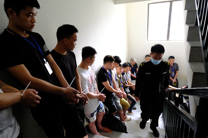 Nhóm lừa đảo cố gắng trốn thoát bằng cầu thang nhưng bị lực lượng công an kịp thời bắt giữ - Ảnh: CACC